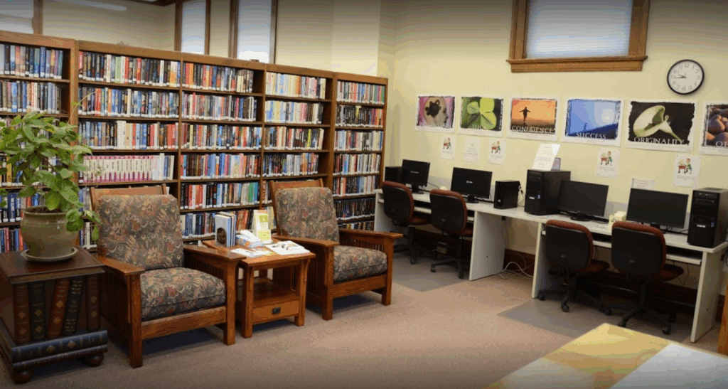Galva Public Library addition with patron computers, large print books, reading chairs and a plant